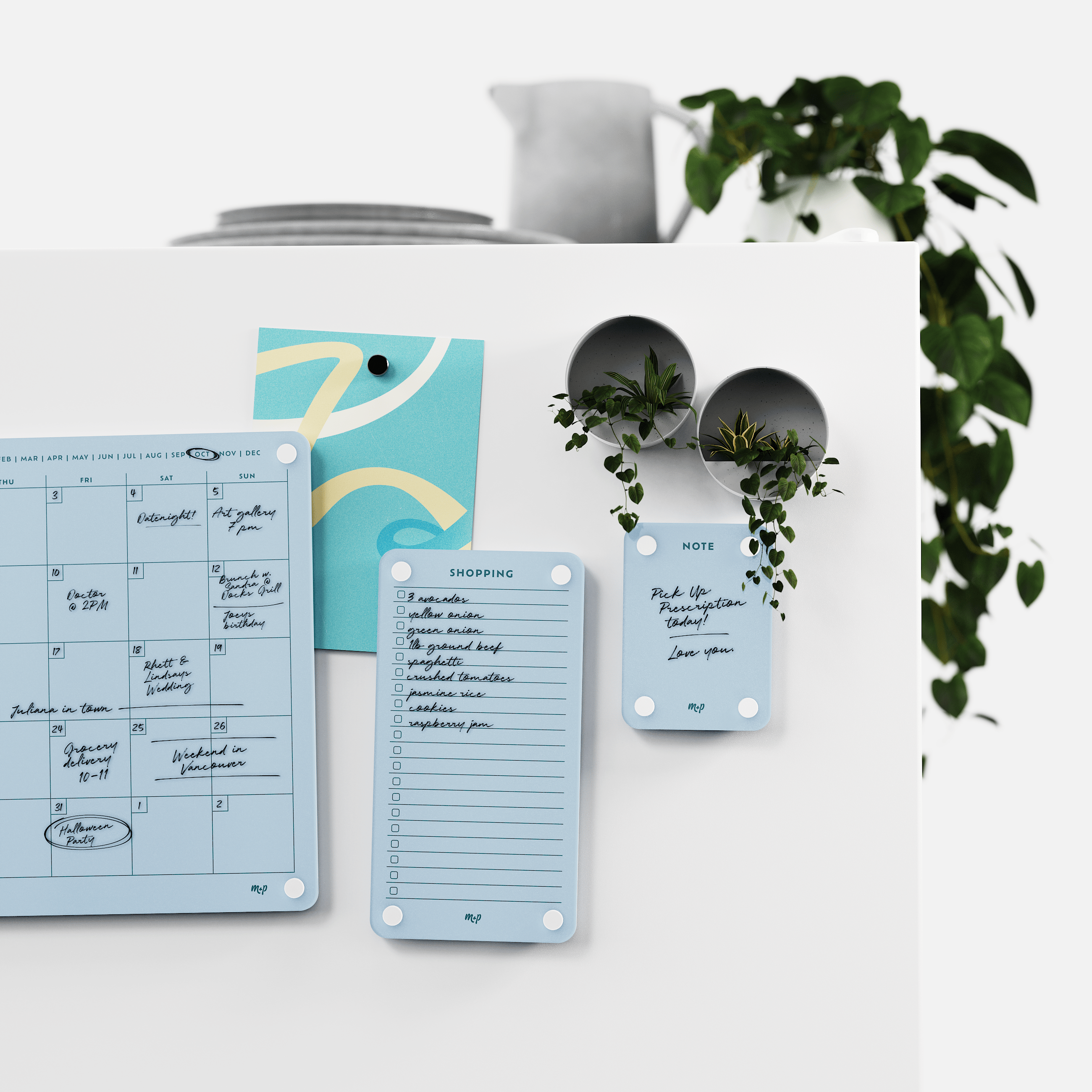 Vista blue monthly calendar, shopping list and note board on a white kitchen wall with magnetic planters